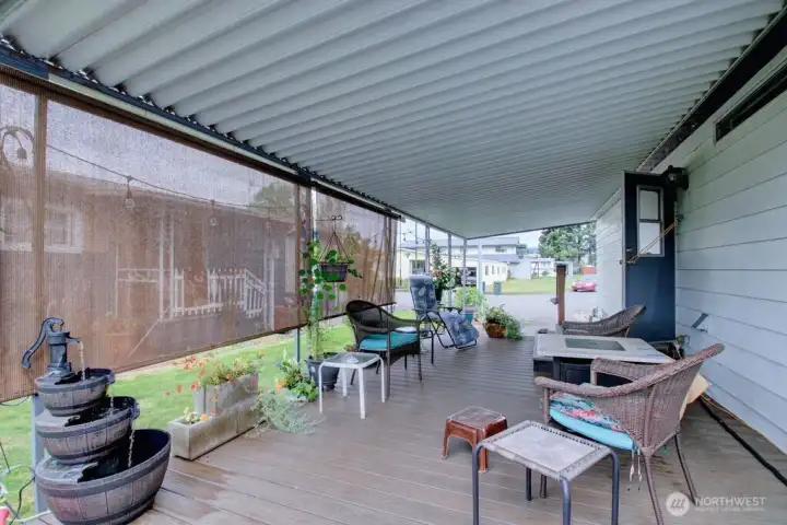 Large covered deck off side entrance to home.