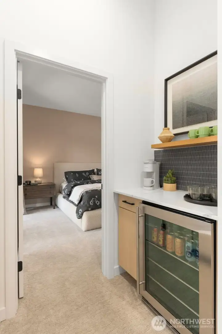 Turn left to the big covered deck, turn right for beverage station, or straight on to your luxurious Primary Suite! Photo is of model home of same floorplan.  Color schemes and finishes will vary per plan.