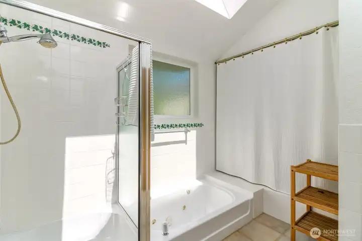 Shower and sunken jetted tub in primary.  Beyond the curtain is the glass wall.