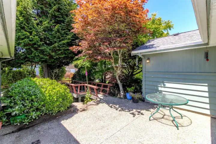 Private back patio with the the walkway leading to the back of the garage.