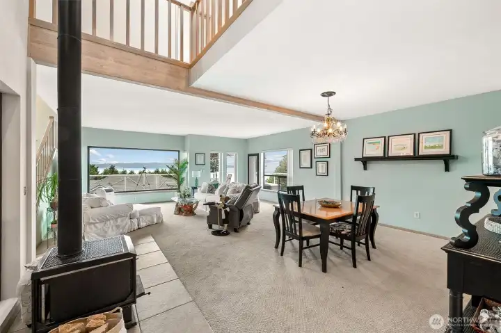 Open concept living/dining room with wood burning stove. Open concept living/dining room with wood burning stove.