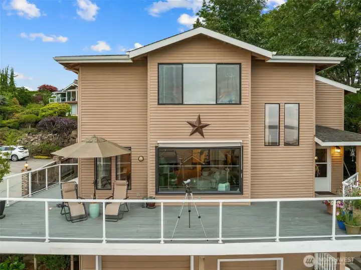 Wrap around deck for entertaining and relaxing. Sunshade over the front window helps with the bright sunsets. Wrap around deck for entertaining and relaxing. Sunshade over the front window helps with the bright sunsets.