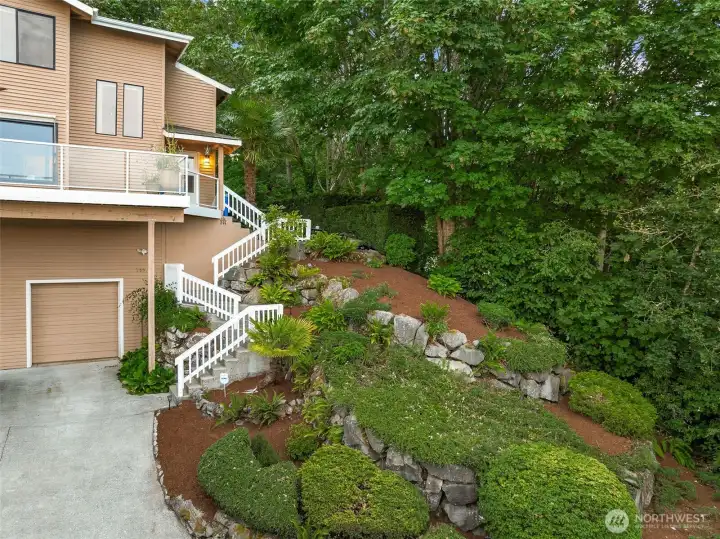 Mature landscaping and staircase to the front door. Mature landscaping and staircase to the front door.