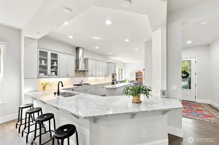 The counter-height bar easily sits an additional 7 people on it's two sides. Kitchen counters are all 3 cm quartz.