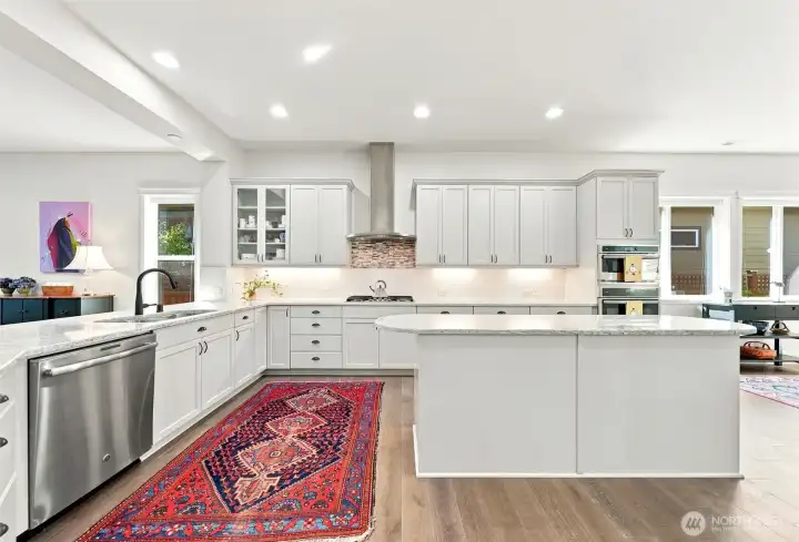 This grand kitchen is FULL of upgrades: Stainless hood vent over 5 burner cooktop; painted kitchen cabinets; 42" upper cabinets with crown moulding; under cabinet lighting.