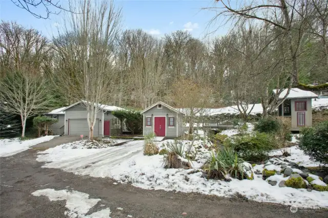 Exterior photo taken from driveway showing garden shed/shop and gazebo.