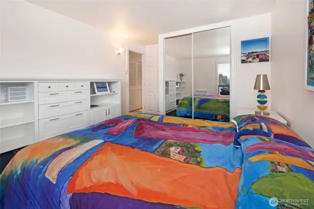 Primary bedroom with built-ins and a mirrored closet.