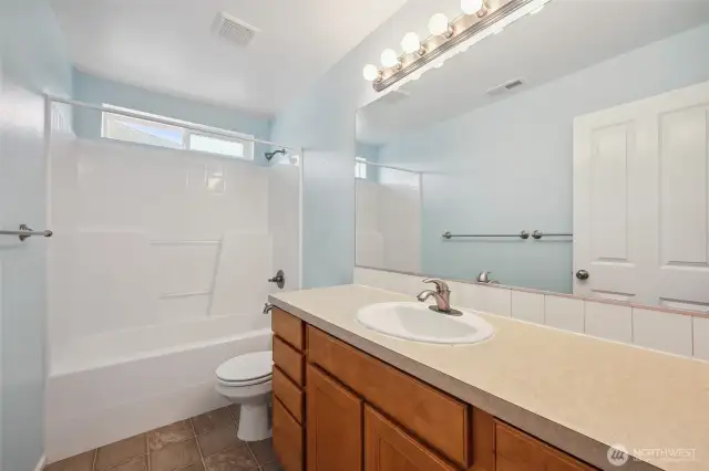 Full bath in hallway between bedrooms.