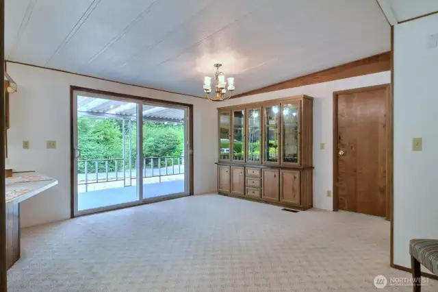 The open dining room sits in front of a sliding glass door overlooking the delightful yard. Lots of room here for large dining table and chairs for several dinner guests.
