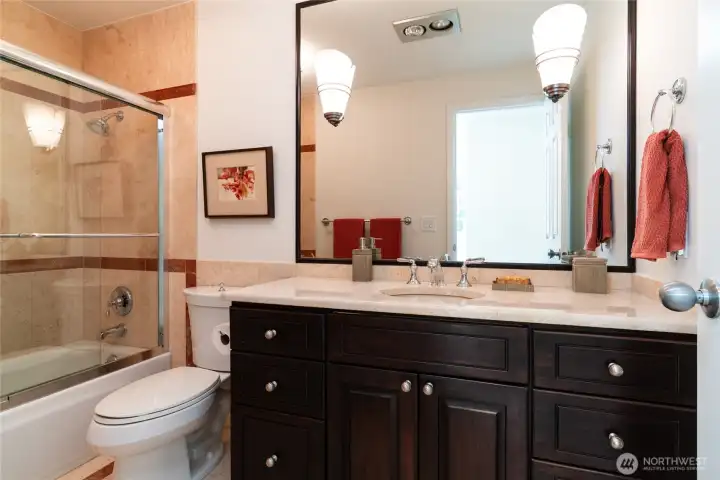 Marble tile throughout the floor, countertops, and tub/shower surround creates a luxurious feel in upstairs main bath