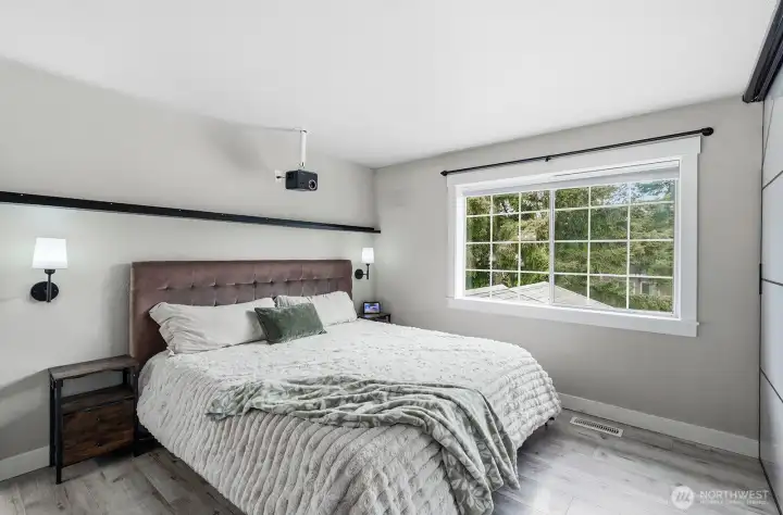 Primary suite with hard surface flooring and oversized window.