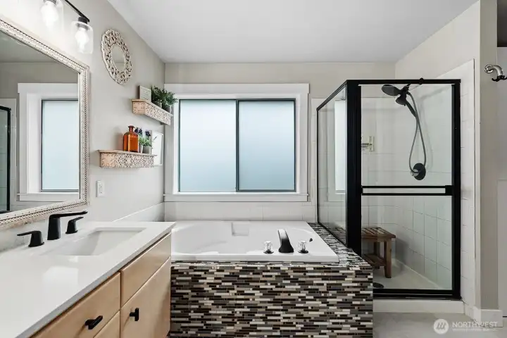 Primary bathroom with double sinks and hard surface countertops.