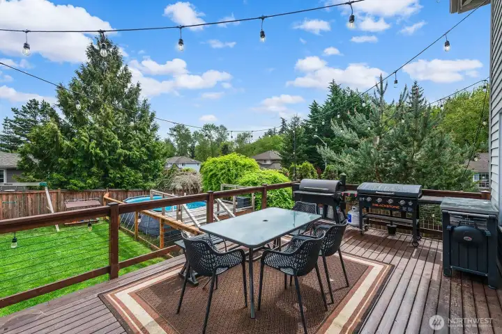 Deck over looks above ground pool and play area in teh back.