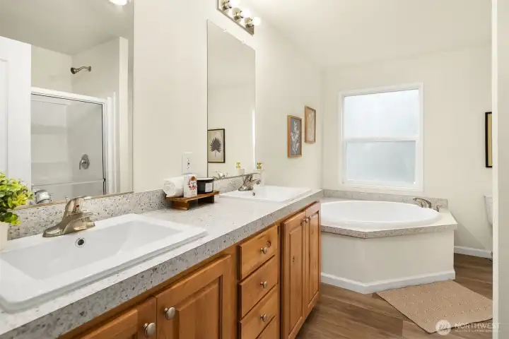 Primary bathroom featuring dual vanities and soaking tub
