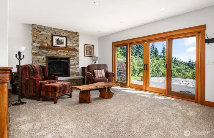This living area in the walk out basement has a propane fireplace with a custom rock tile surround. Expansive glass and wood sliders provide easy access to the stone patio. This living area in the walk out basement has a propane fireplace with a custom rock tile surround. Expansive glass and wood sliders provide easy access to the stone patio.
