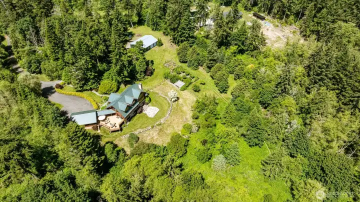 Overhead view of the garage, deck, house, shop, and orchard/garden area. Deer fencing encloses the part of the garden that is a productive orchard and vegetable growing area. Overhead view of the garage, deck, house, shop, and orchard/garden area. Deer fencing encloses the part of the garden that is a productive orchard and vegetable growing area.