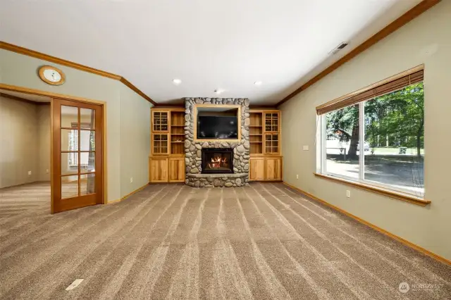 Beautiful built in shelves match the kitchen cabinets, river rock propane fireplace & large picture window looks out onto the private back yard & patio.
