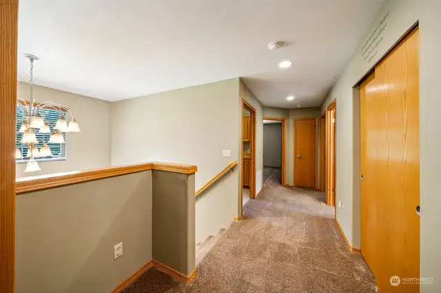 The wide staircase leads you to the upstairs landing over looking the front door vaulted ceilings.