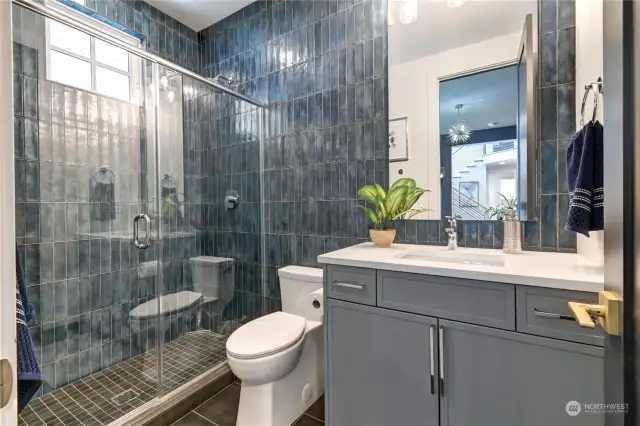 Main Floor bedroom/office bathroom features full wall designer tile.