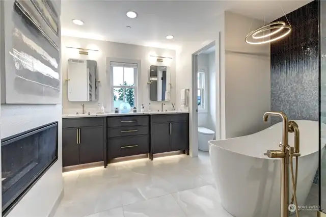 The primary bathroom has heated floors, a soaking tub, see through fireplace, 103" vanity and an amazing bidet