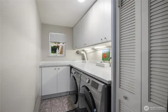 Laundry room with linen closet and more storage.