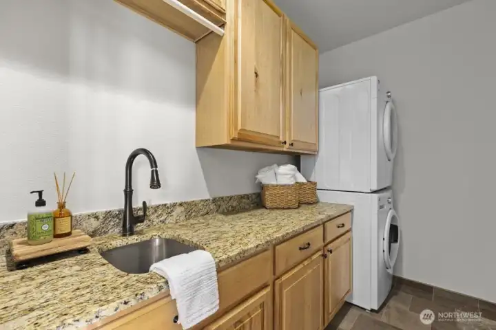 The spacious laundry room makes everyday tasks easier, with granite counters, a utility sink, and washer/dryer ready to go.
