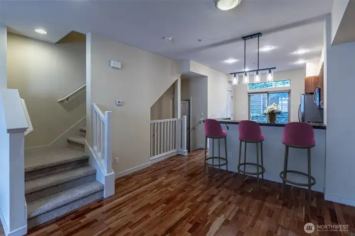Great room looking back to the kitchen with granite eating bar.  Kitchen also has a pantry & room for a small table & chairs if desired.  (Virtually Staged)