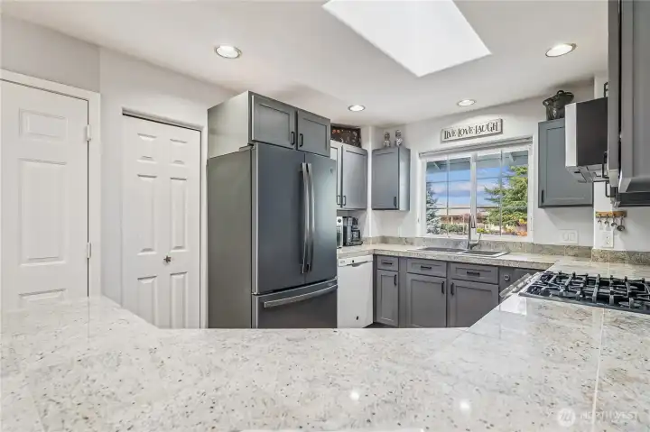 The kitchen features a gas range and a skylight. New sink and a great fridge. Soft close cabinets and a pantry.