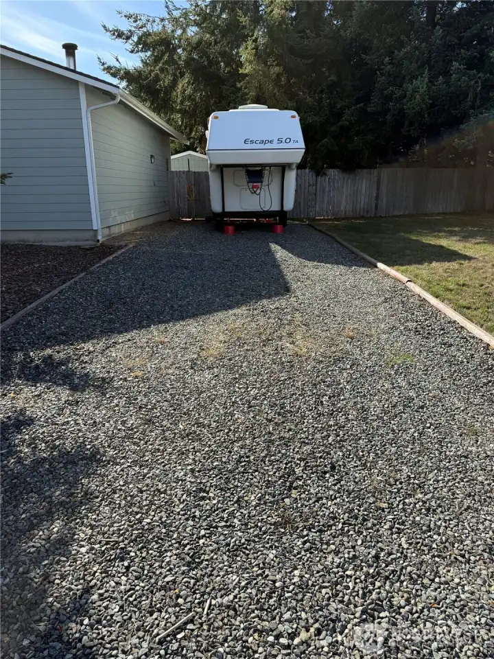 RV Parking with crushed gravel, Water hookup in the front of garage, and 30-amp hookup. Check out the large door opener made of carved wood-so unique.