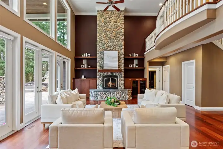 Living room (off the kitchen) with dramatic two story windows, a floor to ceiling gas river rock fireplace, and a series of French doors opening to the expansive backyard. A true Pacific Northwest oasis.