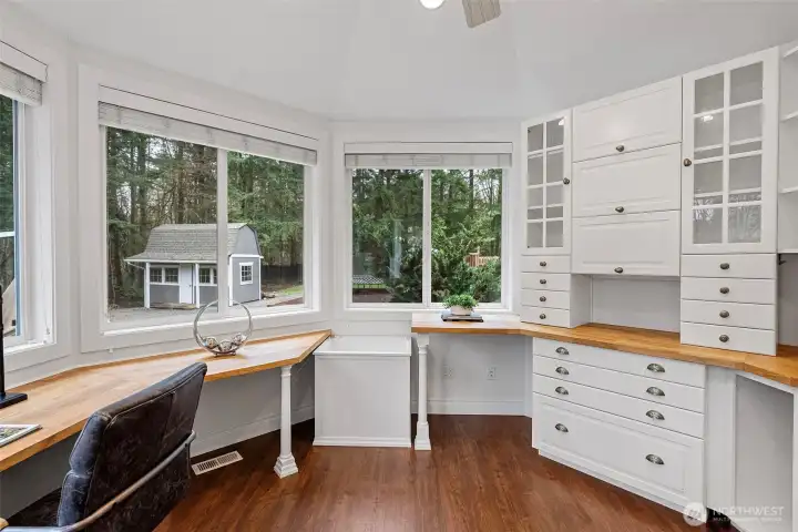 Office off the primary bedroom with wraparound windows that flood the space with natural light, complemented by abundant storage to keep everything organized and within reach.