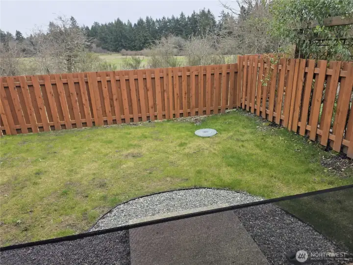 Yard to the right, facing the greenbelt, open space.