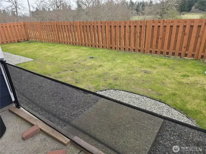 Yard to the left, facing the greenbelt, open space.