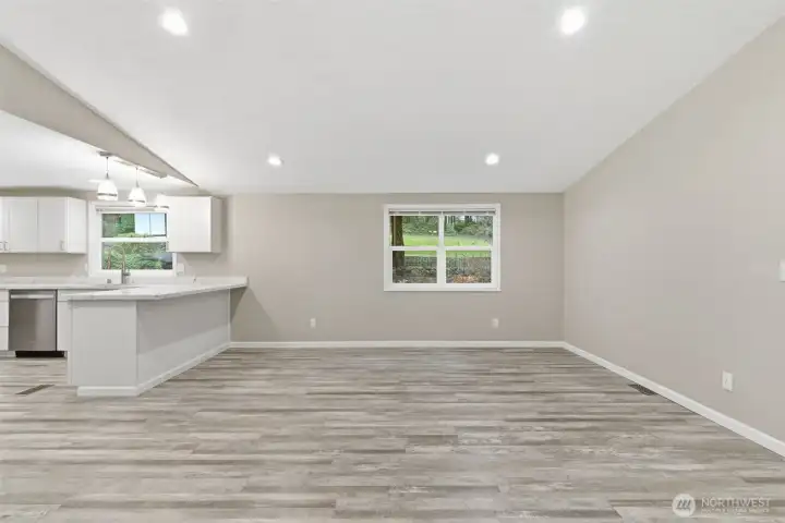 Living room off kitchen, featuring vaulted ceilings.