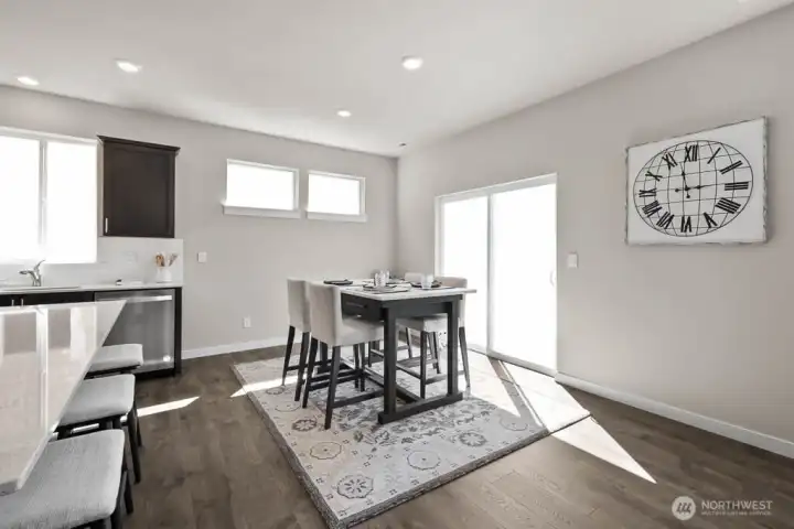 Open concept living with connectivity between great room, kitchen and dining space with oversized slider to large backyard. Photo is representational. Actual home is under construction and finishes, and paint colors may vary. See site agent for details.