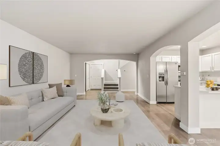 The expansive great room creates a seamless flow and clear sight lines from the kitchen to dining and living spaces. (Virtual Staging)