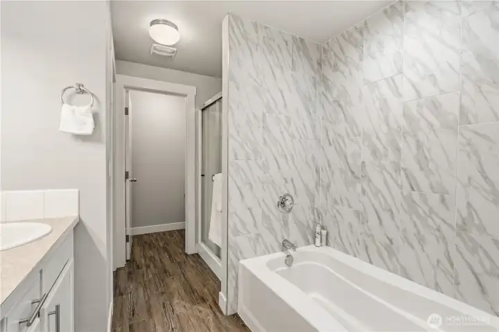 Relax at the end of the day with a warm bath in the floor-to-ceiling tiled surround bathtub.