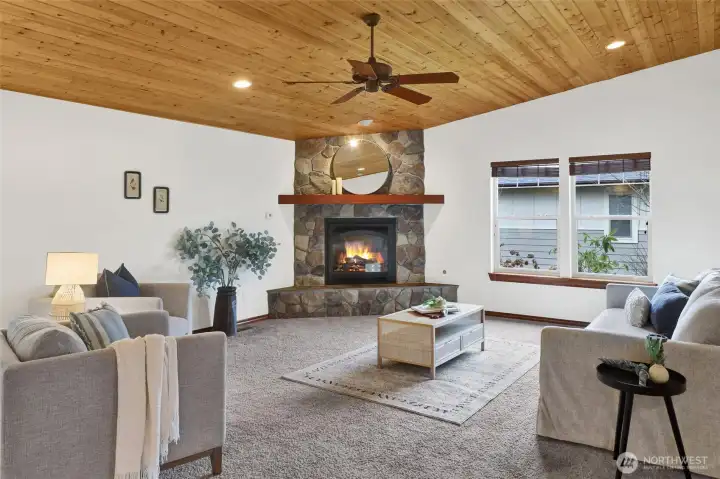 Open living room with gas fireplace and slightly vaulted tongue and groove ceilings.