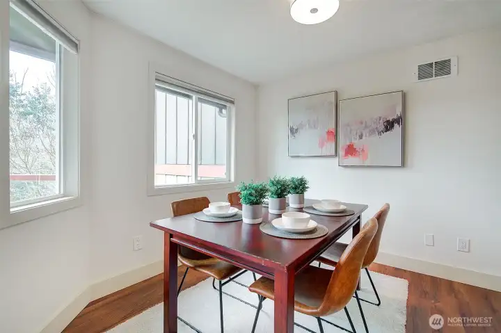 The dining room view overlooks the tree lined scenery surrounding this home.