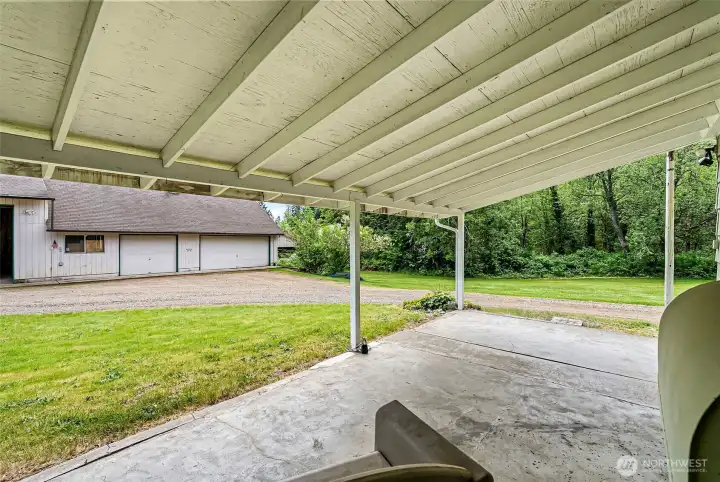 Covered back patio looking at the 3-car garage and RV bays