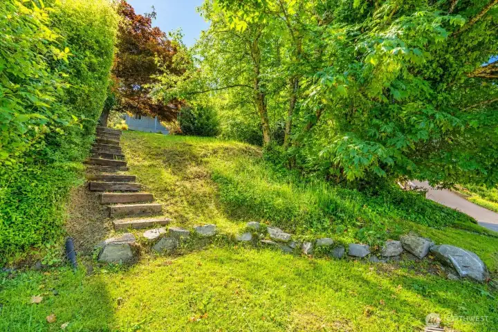 Standing down on State Street, stairs lead up to the yard that provide easy access down to the S Bay Trail, which connects to downtown and Boulevard Park.