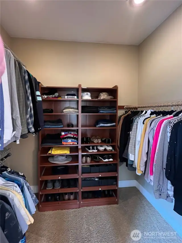 Walk-in closet with more custom cabinetry.