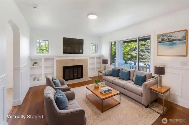Cozy living room w/ wood burning fireplace, built in shelving and natural hardwood floors.