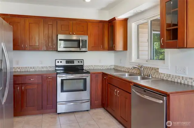 Open concept kitchen w/ wood cabinets and stainless steel appliances.