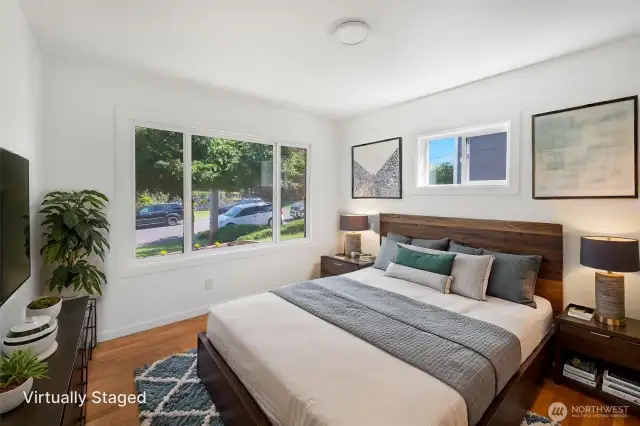 North bed room with wood floors and bright windows.