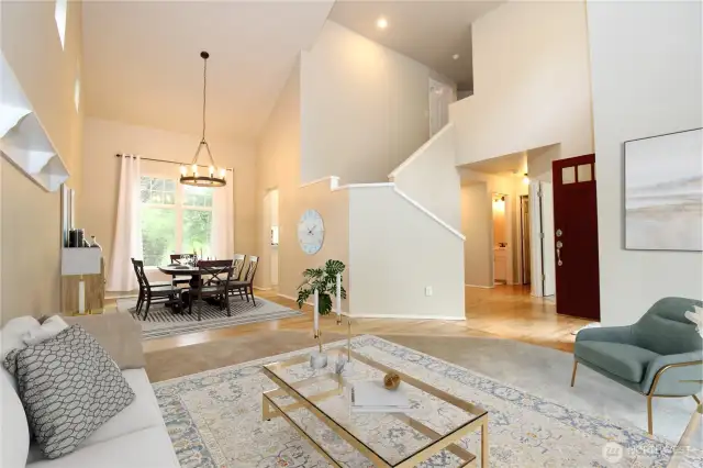 Step inside to a bright open floor plan with large windows, a vaulted ceiling, & hardwood floors.