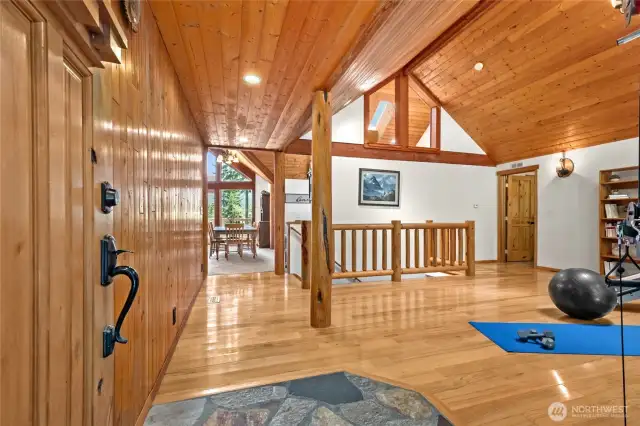 the welcoming living room features gleaming hardwood floors and a vaulted ceiling, creating a warm and inviting space.