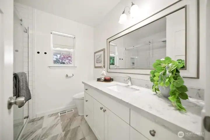 Recently updated bath with walk in  tile shower and quartz counter.