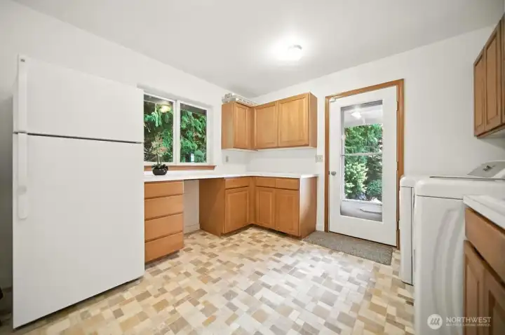 No shortage of space in this laundry area and the refrigerator/freezer and washer and dryer convey. The door exits to the main floor covered deck.