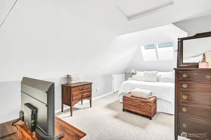 The primary bedroom, with 2 walk-in closets, en suite bath, extra storage & stylish ceilings, oozes charm.